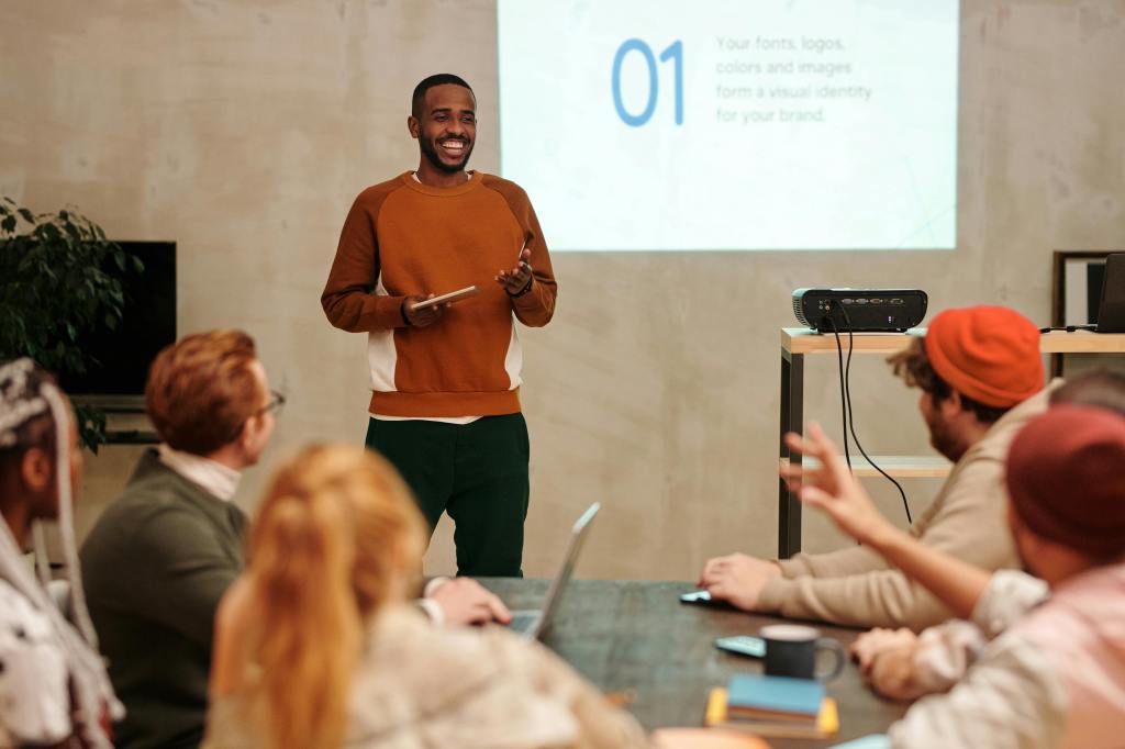 A young black man giving a presentation in front of a group of people.
